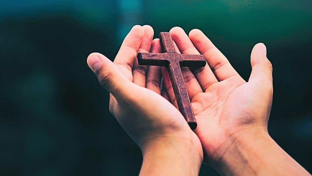 Hands hold cross. For "My Worth."